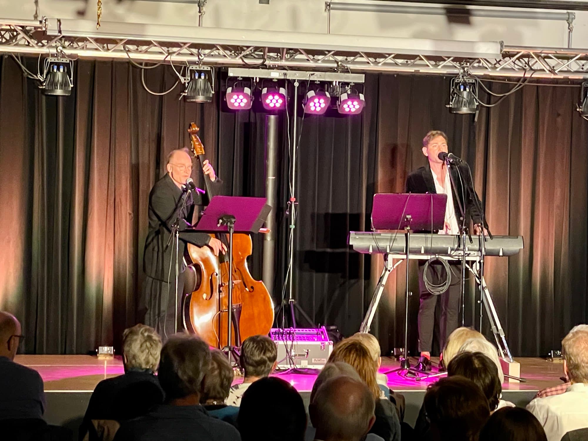 Konzert in einem kleinen Saal, das Publikum schaut zur Bühne